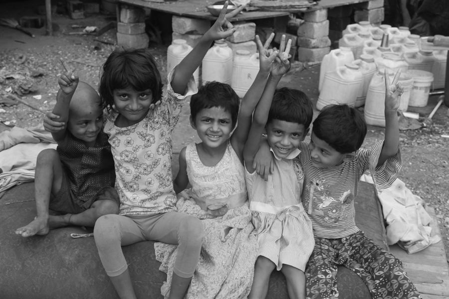 A group of children smiling and making peace signs at the camera